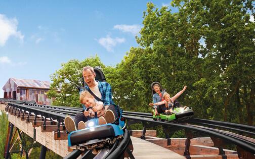 rollercoaster Dawson duel, met rechts een vader en zoon en links een moeder en dochter in een wagentje