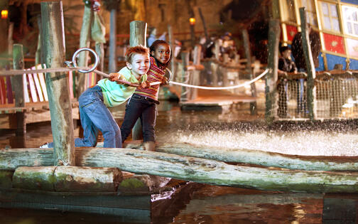 Kinderen op een vlot op het water in Plopsa Indoor Hasselt