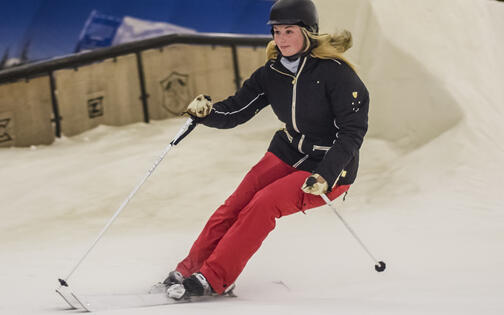 vrouw met rode broek skiet naar beneden op de piste van Ice Mountain Adventure Parc
