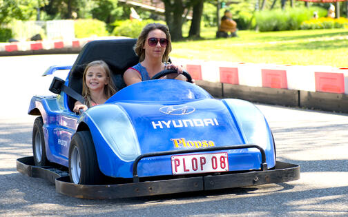 moeder en dochter in een blauw racewagentje op het kartingcircuit