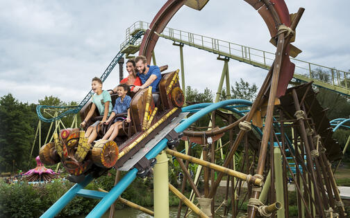 gezin op rollercoaster Tikiwaka, een coaster die boven het water gaat