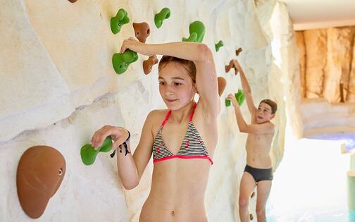 2 kinderen in zwemkleding aan de klimmuur in Bellewaerde aquapark