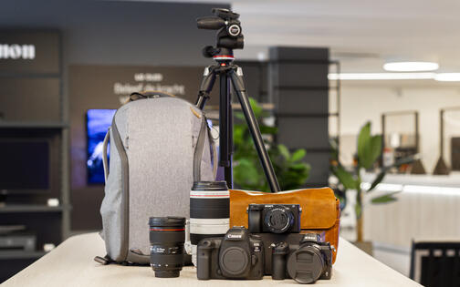 stand met fotomateriaal waaronder statief, lenzen en fototoestellen en tas voor fotomateriaal