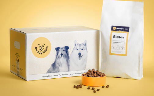 doos met logo buddybites + foto twee honden, zak hondeneten, gele eetkom met hondenbrokken erin en ernaast  