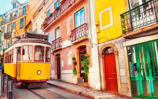 typische tram in klein straatje met gekleurde huizen in Lissabon