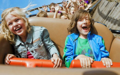 2 kinderen die lachen in de houten achtbaan