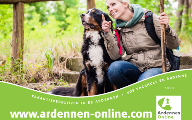 vrouw zit naast hond en wijst naar iets in de natuur, het is de cover van een brochure van Ardennen online dus de naam en logo van het vakantiepark staan op het beeld