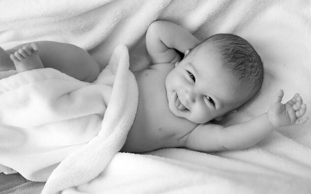 zwart wit foto van een lachende baby