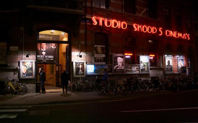 foto van de ingang van de Studioskoop als het al donker is