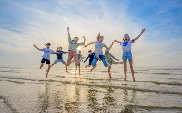 kinderen op het strand springen in de lucht