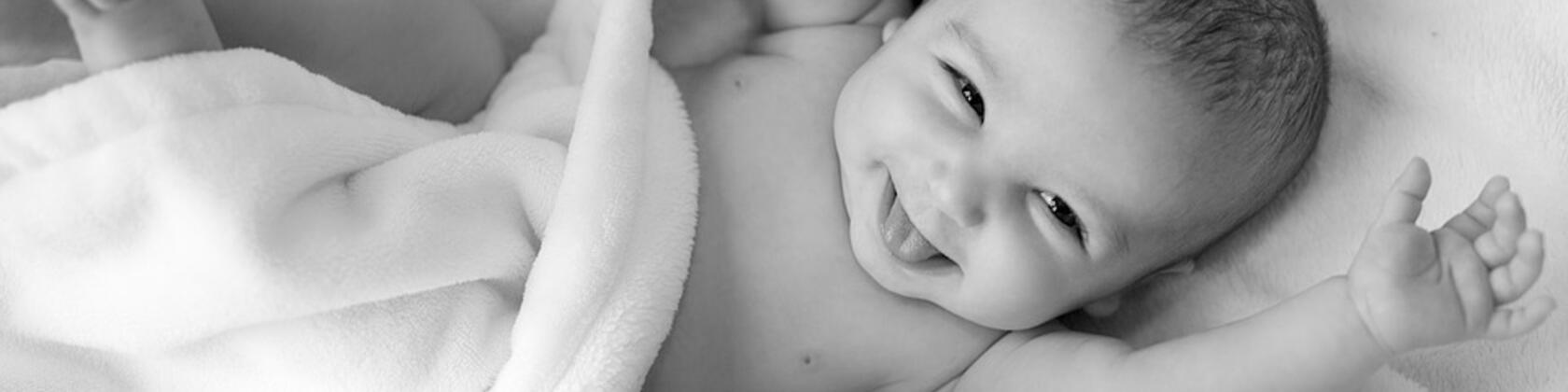 zwart wit foto van een lachende baby