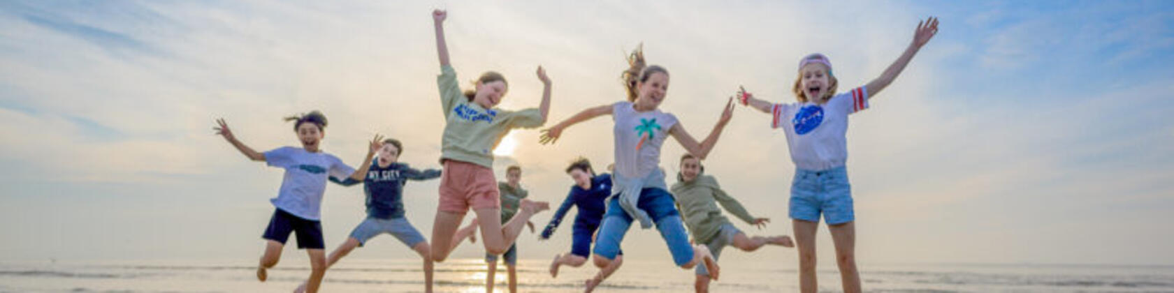 kinderen op het strand springen in de lucht